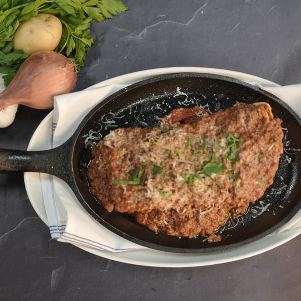 Grano's Italian dish, a skillet of pasta with rich bolognese sauce, parmesan, and fresh parsley.